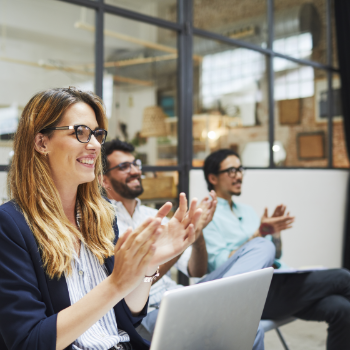 Team members clapping at a meeting